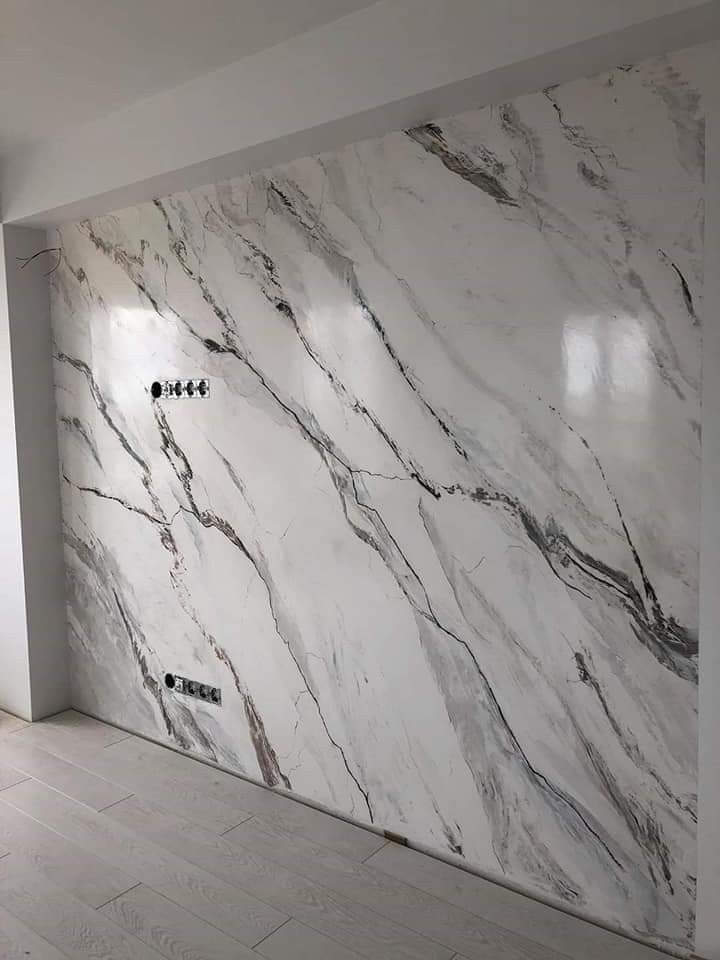 جدار مغطى ببديل الرخام الفاخر بلون أبيض مع عروق رمادية في تصميم حديث داخل منزل بالمدينة المنورة